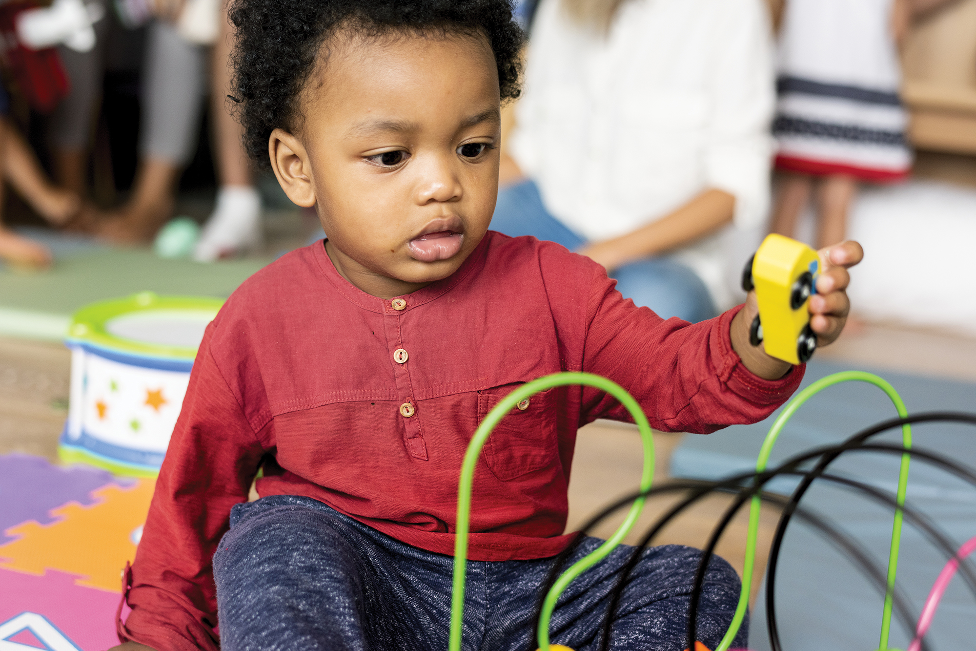 Small child playing with a toy car